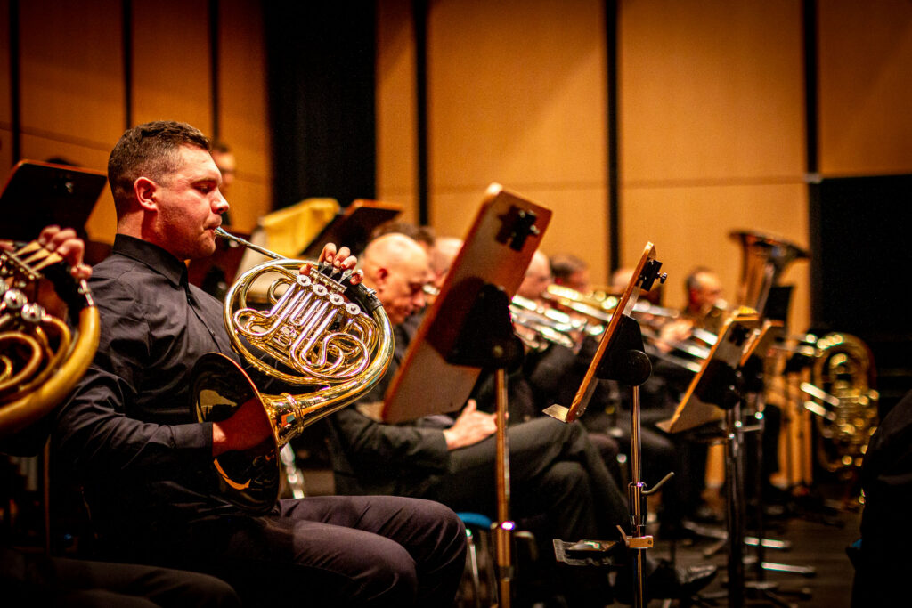 Mann spielt goldene Waldhorn im Orchester, Nahaufnahme